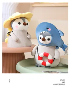 Primer plano de suaves peluches de pingüino con disfraces de tiburón y flor y salvavidas