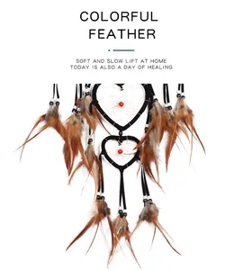 Detailed view of brown feathers and heart-shaped rings of an Indian style dreamcatcher