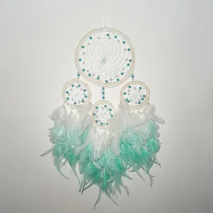 Detail view of the four-ring vine dreamcatcher featuring mint green and white feathers