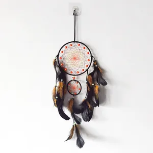 Dettaglio dell'acchiappasogni boho fatto a mano con piume nere e perline colorate