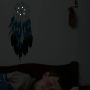 Acchiappasogni luminoso con piume blu sopra un bambino che dorme nella notte