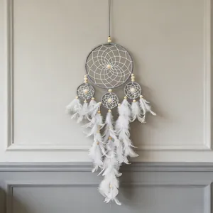 Detail of a handmade grey and white four-ring dreamcatcher with feathers and wooden beads