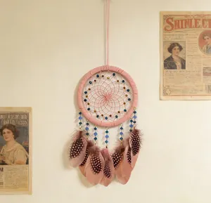 Atrapasueños bohemio rosa hecho a mano con plumas moteadas y cuentas azules detalle