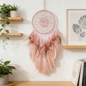 Detailed view of a pink tree of life dreamcatcher hanging on a wall with plants