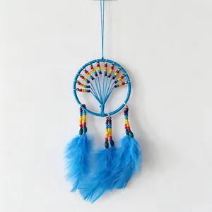 Detailed view of a vibrant blue dreamcatcher featuring rainbow beads and soft blue feathers