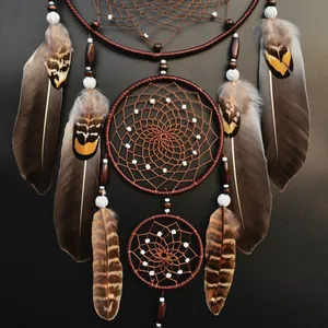 Atrapasueños artesanal marrón de tres aros con plumas naturales y cuentas blancas