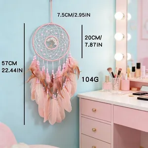 Attrape-rêves Arbre de Vie rose avec plumes et perles dans un décor de style de vie.