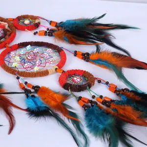 Détail d'un attrape-rêves indien artisanal avec plumes colorées et perles