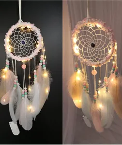Vue détaillée d'un attrape-rêves en plumes roses avec lumières LED et perles colorées