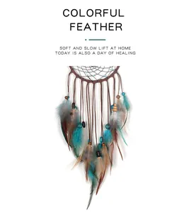 Détail d'un attrape-rêves avec des perles turquoise et des plumes colorées.