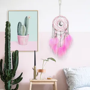 Handmade Mori-style dreamcatcher wall hanging with vibrant pink feathers and moon charm