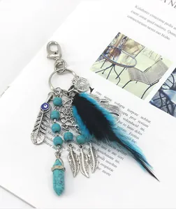 Detailed view of bohemian dreamcatcher keychain with blue feathers and turquoise beads