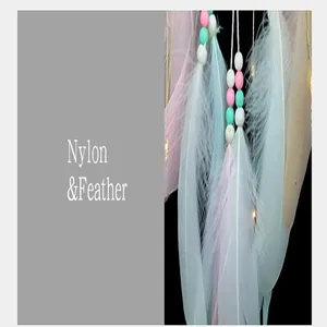 Vue macro des plumes et perles en nylon sur un attrape-rêves rose pour chambre de fille