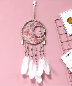 Detail of sun and moon dreamcatcher with white feathers and butterfly accents for room decor