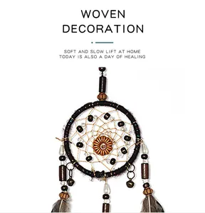 Detail of vintage Indian style dreamcatcher with brown feathers and woven bead ornaments