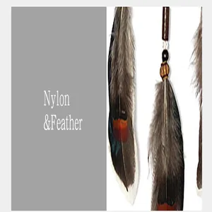 Macro detail of vintage Indian style car hanging charm featuring nylon and natural feathers