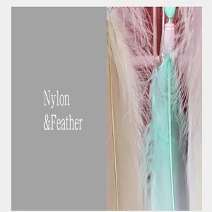 Dettaglio ravvicinato di piume rosa e verdi con filo di nylon di un acchiappasogni