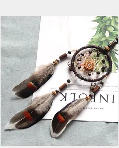 Detailed view of a retro Indian style dreamcatcher with feathers and beads on a magazine