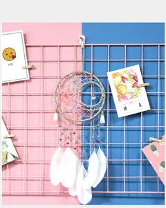 Handmade sun moon dreamcatcher with white feathers on pink blue grid wall decoration