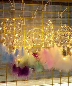 Detalle de atrapasueños de luna hechos a mano con luces LED cálidas y plumas vibrantes