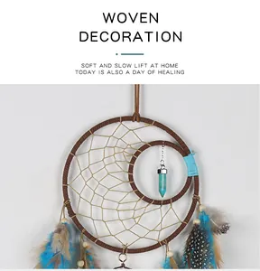 Close-up detail of vintage Indian dreamcatcher with blue feathers and crystal pendant.