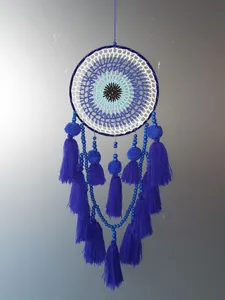 Detail view of blue evil eye dreamcatcher with handmade crochet and tassels
