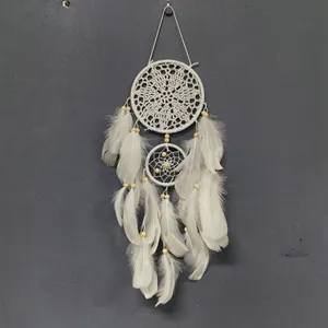 Detalle de un atrapasueños bohemio blanco con encaje de ganchillo y plumas suaves