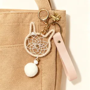 Cute cat-shaped dreamcatcher keychain with white plush pom-pom and pink leather strap