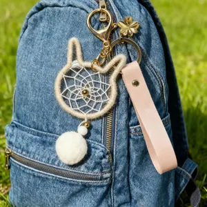 Adorable cat-shaped dreamcatcher keychain with a fluffy white pom-pom and pink strap