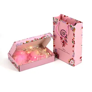 Detalle de bolsa y caja de regalo de atrapasueños rosa con luces LED y plumas