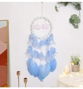 Atrapasueños de pared con plumas azules y flores blancas en un ambiente acogedor
