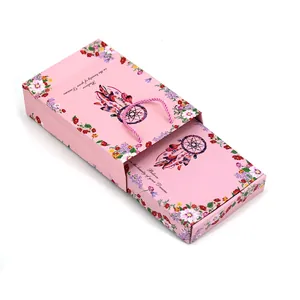 Vista detallada del patrón floral y el atrapasueños en una caja de regalo rosa tipo cajón