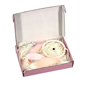 Atrapasueños rosa hecho a mano con plumas en una caja de regalo a juego con relleno