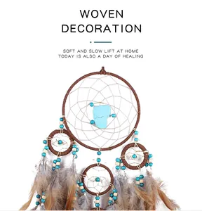 Handcrafted woven dreamcatcher with blue beads and soft natural feathers for wall decor.