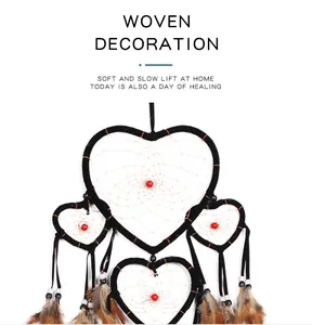 Detailed macro view of a heart-shaped dream catcher with brown feathers and red beads