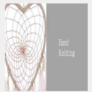 Detailed macro view of a white heart-shaped dream catcher showing hand-knit web