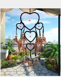 Detailed view of heart-shaped dreamcatcher with brown feathers and red beads decor