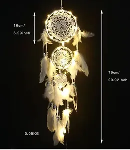 Detailansicht eines weißen Traumfängers mit drei Ringen, LED-Lichtern und Federn
