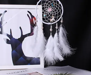 Vue détaillée d'un attrape-rêves blanc avec breloques licorne et plumes