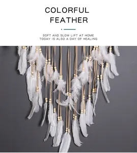 Detalle de plumas blancas y cuentas en un gran atrapasueños bohemio.