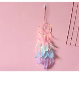 Vue détaillée d'un attrape-rêves pastel avec des lumières LED sur un mur rose décor