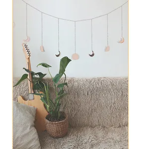 Boho Mondphasen-Wandbehang in einem gemütlichen Wohnzimmer mit Gitarre und Pflanze
