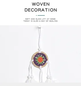 Detail of small woven dreamcatcher wall hanging with white feathers and beads