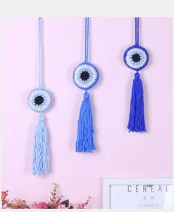 Detailed view of three hand-knitted crochet Evil Eye hanging ornaments in various blue shades