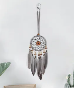 Macro view of retro gray dreamcatcher with soft feathers and a pumpkin gear center