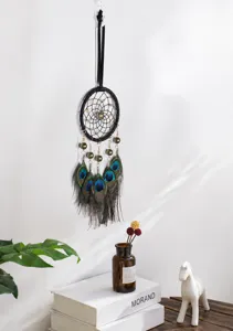 Vue détaillée d'un attrape-rêves en plumes de paon fait main sur un mur blanc épuré