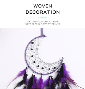 Close-up of handmade moon dreamcatcher with purple and black feathers and beads.