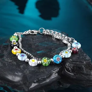 Detailaufnahme eines zweischichtigen Armbands mit bunten Glasperlen auf schwarzem Stein