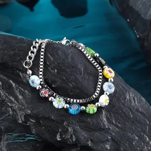 Detail eines doppellagigen Armbands mit bunten Glasperlen und Silberketten