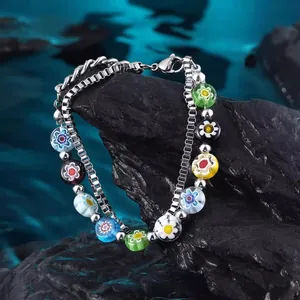 Detailaufnahme eines farbenfrohen Millefiori-Glasperlen-Doppelschichtarmbands auf dunklem Fels.